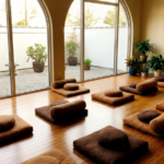 Peaceful meditation hall with cushions and soft natural light at beginner-friendly retreat center