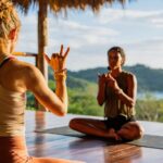 Two women practicing yoga on an ocean view deck at Eden on the Chocolata retreat, San Juan del Sur, Nicaragua